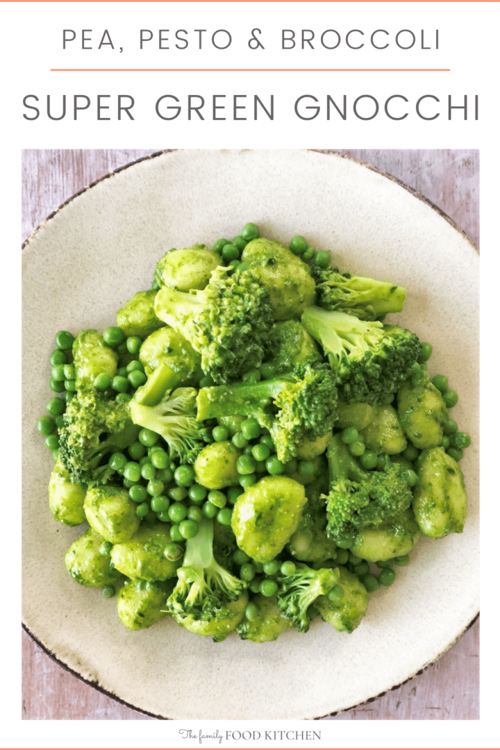 Pinnable image with recipe title and bowl of cooked gnocchi in a pesto sauce with cooked broccoli and green peas.