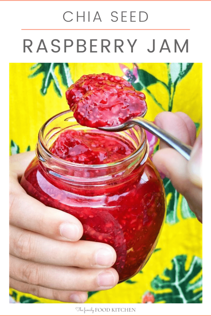 Pinnable image with recipe title and pair of hands holding a jar of raspberry jam and a spoon loaded with jam.