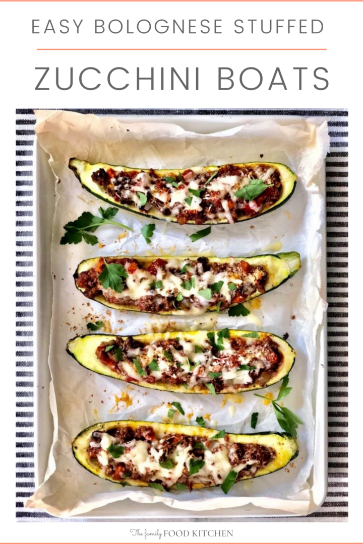 Pinnable image with recipe title and cooked stuffed zucchini boats in a sheet pan lined with baking paper.