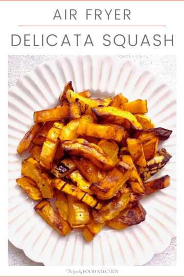 Pinnable image with recipe title and image of sliced and roasted delicata squash set on a white plate.