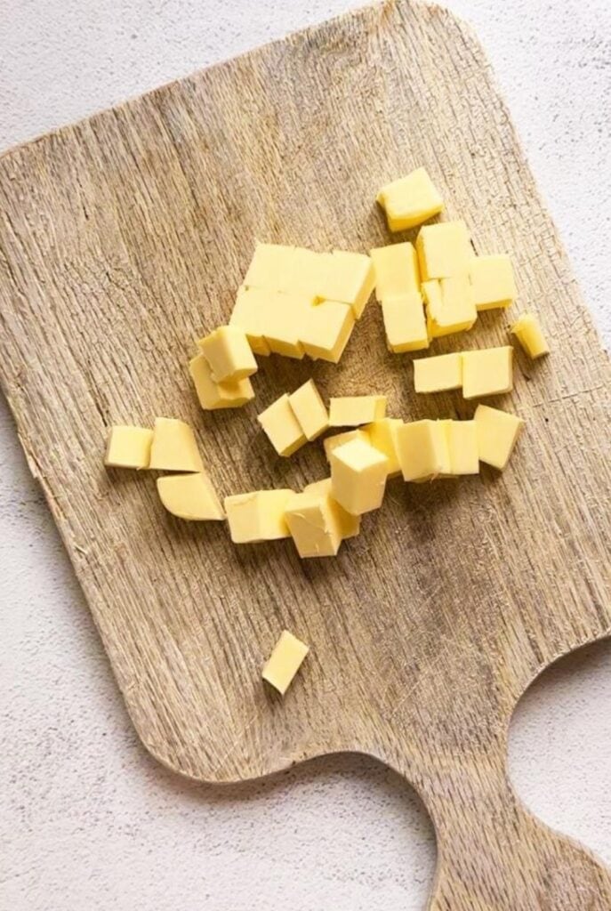 A wooden board topped with cubes of cold butter.