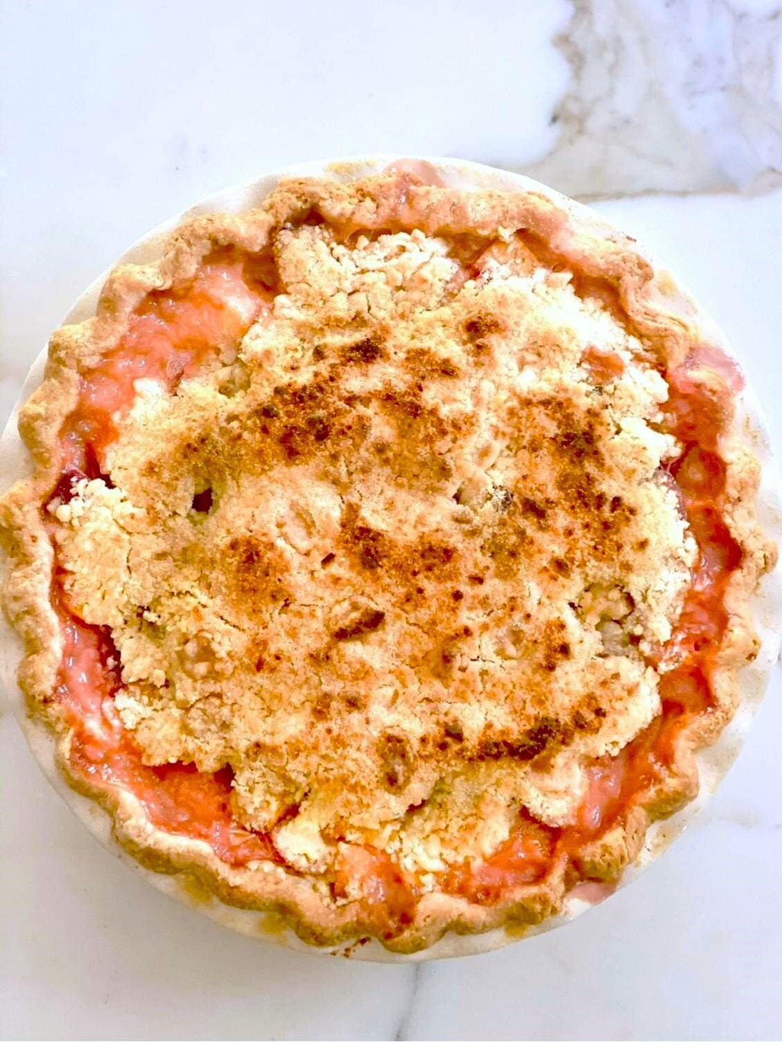 A golden baked peach pie with a crumble topping.
