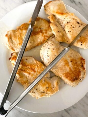 A plate of 4 chicken breasts cooked until golden brown.