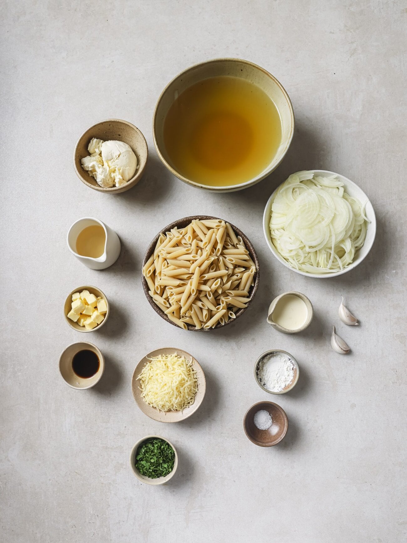 Individual recipe ingredients for making cheesy French onion soup pasta.