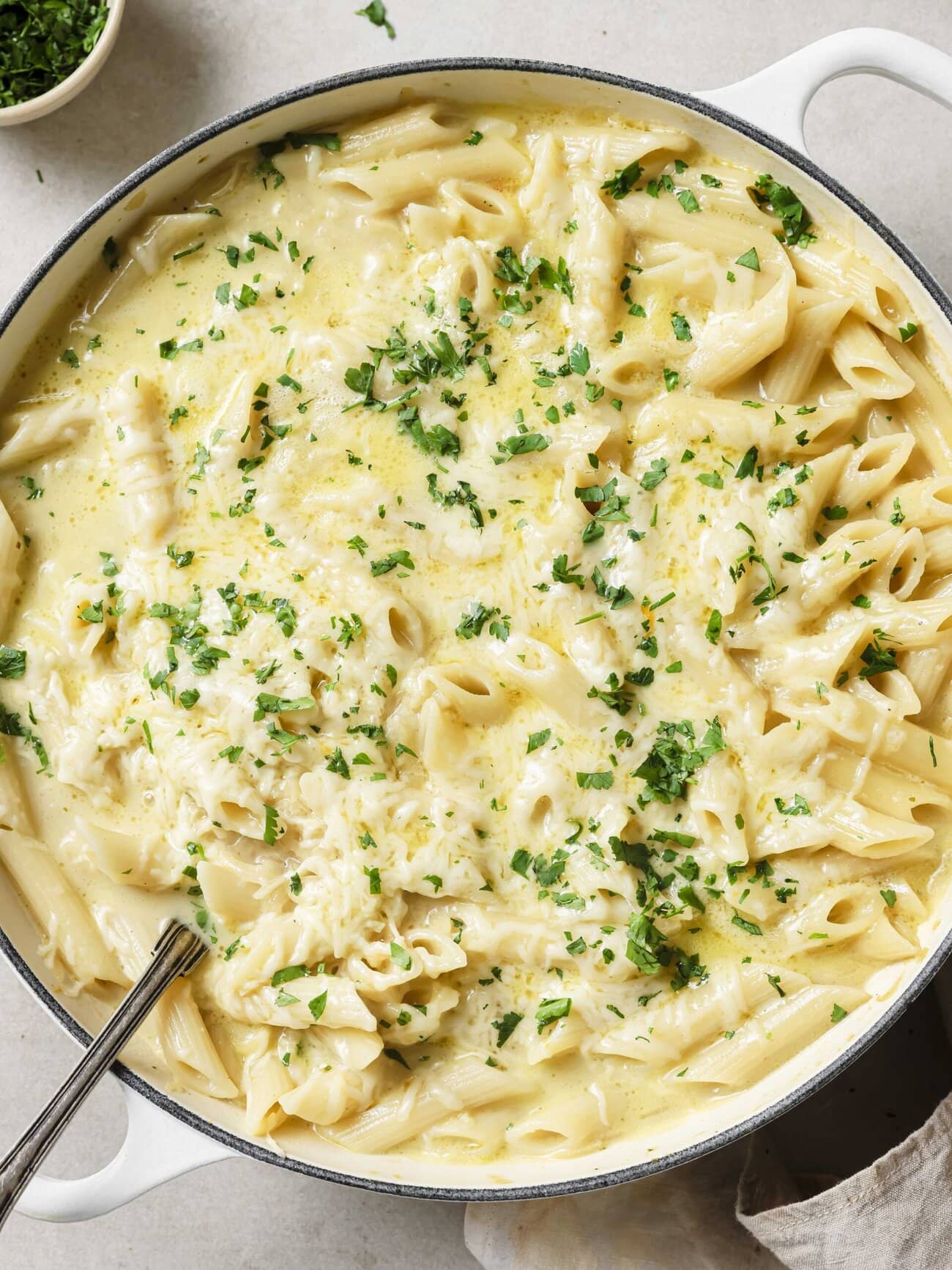 A large skillet filled with creamy cheesy French Onion Soup Pasta garnished with fresh parsley.
