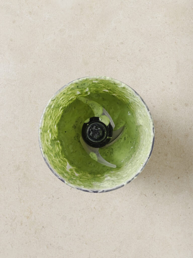 A bowl of green herb and Greek yogurt dressing.