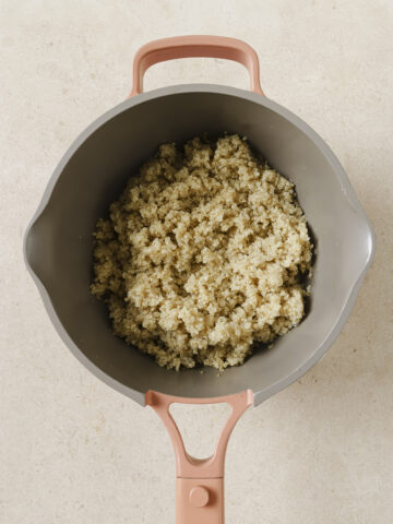 A saucepan filled with cooked quinoa.
