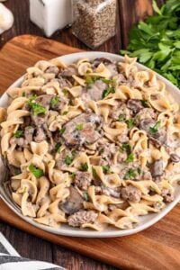 A bowl of ground beef and mushroom stroganoff served with fusilli pasta noodles.