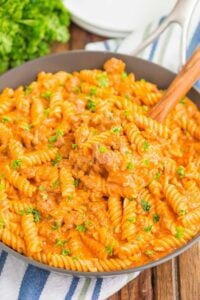 A large skillet of creamy ground beef pasta.