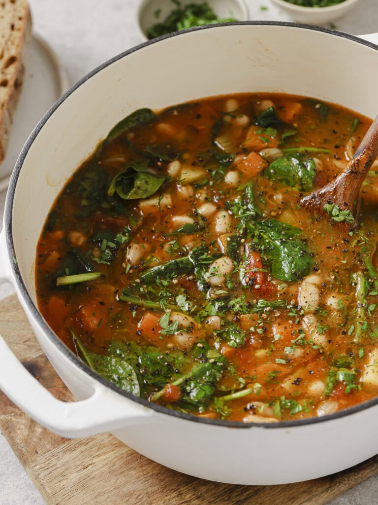 Finished Ikarian longevity stew with spinach and white beans in the pot